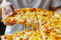 Close up of a woman\'s hand holding a piece of pizza Royalty Free Stock Photo