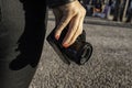 Close up of a woman`s hand holding a professional film camera shooting in the streets of Lisbon in Portugal