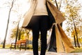 Close-up of woman`s hand holding shopping bags on the street, woman in beige raincoat and autumn shoes Royalty Free Stock Photo