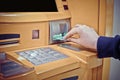 Close-up of woman`s hand inserting debit card into an ATM machin Royalty Free Stock Photo