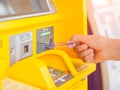 Close-up of woman`s hand inserting debit card into an ATM machin Royalty Free Stock Photo