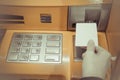 Close-up of woman`s hand inserting debit card into an ATM machin Royalty Free Stock Photo