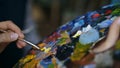 Close up of woman`s hand mix paints with brush in palette and painting still life picture on canvas in artist studio Royalty Free Stock Photo