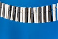 Close-up of a woman`s hand playing the imaginary piano made from clothes pins on blue paper background. Royalty Free Stock Photo