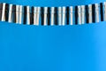 Close-up of a woman`s hand playing the imaginary piano made from clothes pins on blue paper background. Royalty Free Stock Photo