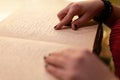 close-up of a woman's hand reading a braille book