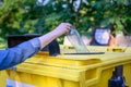 Close-up of a woman`s hand tossing an empty plastic bottle into a trash can Royalty Free Stock Photo