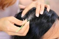 Close up Woman`s hand using tweezers to plucking gray hair roots from head