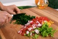 Close up of woman`s hands cooking in the kitchen. Housewife slicing fresh salad. Vegetarian and healthily cooking Royalty Free Stock Photo