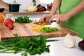 Close up of woman`s hands cooking in the kitchen. Housewife slicing fresh salad. Vegetarian and healthily cooking Royalty Free Stock Photo