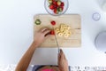 Woman`s hands while she cutting strawberries and banana over wooden table in the kitchen Royalty Free Stock Photo