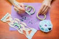 Close-up woman`s hands, decorating bracelets with colorful shiny rhinestones