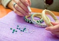 Close-up woman`s hands, decorating bracelets with colorful shiny rhinestones