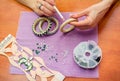 Close-up woman`s hands, decorating bracelets with colorful shiny rhinestones