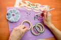 Close-up woman`s hands, decorating bracelets with colorful shiny rhinestones