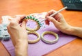 Close-up woman`s hands, decorating bracelets with colorful shiny rhinestones