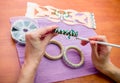 Close-up woman`s hands, decorating bracelets with colorful shiny rhinestones