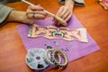 Close-up woman`s hands, decorating bracelets with colorful shiny rhinestones