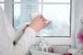 Close up of woman`s hands holding a cup of hot tea or coffee and looking at the window at home in the morning evening Royalty Free Stock Photo