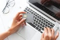 Close up of a woman& x27;s hands holding a gray credit card in front of a laptop computer Royalty Free Stock Photo