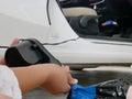 A woman`s hands holding and using mini air pump, connected to the car plug, to inflate a rocking doll Royalty Free Stock Photo
