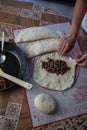 Close up of a woman`s hands making dough for homemade bread, on a silicone baking sheet. frying pan with grinned meat on the side