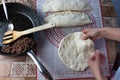 Close up of a woman`s hands making dough for homemade bread on a silicone baking sheet. frying pan with grinned meat on the side