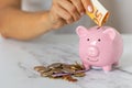 Close-up of a woman's hands put euro paper money in a piggy bank, next to a calculator on the table. crisis and inflation Royalty Free Stock Photo