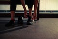 Close up woman's hands tying shoelaces on sneakers in gym Royalty Free Stock Photo