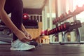 Close up of woman`s hands tying shoelaces on sneakers in the gym Royalty Free Stock Photo