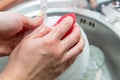 Close up woman`s hands of washing dishes in kitchen sink. Cleaning chores Royalty Free Stock Photo