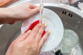 Close up woman`s hands of washing dishes in kitchen sink. Cleaning chores Royalty Free Stock Photo