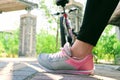 Close-up of a woman's leg wearing a gray-pink sneaker. Bicycle and concrete columns in the background Royalty Free Stock Photo