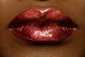 Close-up of woman's lips with bright fashion dark red glossy makeup. Macro lipgloss cherry make-up. kiss