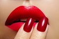 Close-up of woman`s lips with fashion red make-up and manicure. Beautiful female full lips with perfect makeup