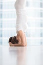 Close up of woman in salamba sirsasana near floor window Royalty Free Stock Photo