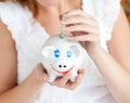 Close-up of a woman saving money in a piggy-bank Royalty Free Stock Photo