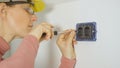 CLOSE UP: Woman screwing screws into wall while installing electrical sockets Royalty Free Stock Photo