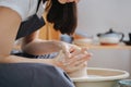 Close up of woman shaping clay vase on a pottery wheel in her private workshop