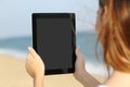 Close up of a woman showing a blank tablet screen on the beach
