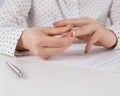 Close-up woman signed divorce papers and took off her wedding ring
