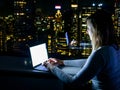 CLOSE UP: Woman sits in her hotel room above Times Square and works on laptop Royalty Free Stock Photo