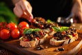 close-up of a woman spooning tapenade onto bruschetta