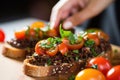 close-up of a woman spooning tapenade onto bruschetta