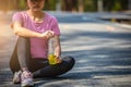 Close-up of woman sport athletes and electrolytes. Asian woman dehydrated sweating after outdoor running exercise