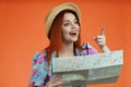 Close up of woman in straw hat smiling, holding paper map pointing finger at the side, found direction, isolated on Royalty Free Stock Photo