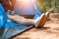 Close up of woman strecthing feet with shoe with nature background. Tourist woman resting in camping tent. People and lifestyles