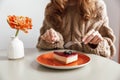 Close up of a woman in sweater eating cheesecake