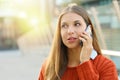 Close up of woman talking on the phone taking a conversation in autumn on modern street background