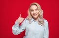 Close up woman with thumbs up, isolated on red background. Like concept. Yes gesturing, sings of good work Royalty Free Stock Photo